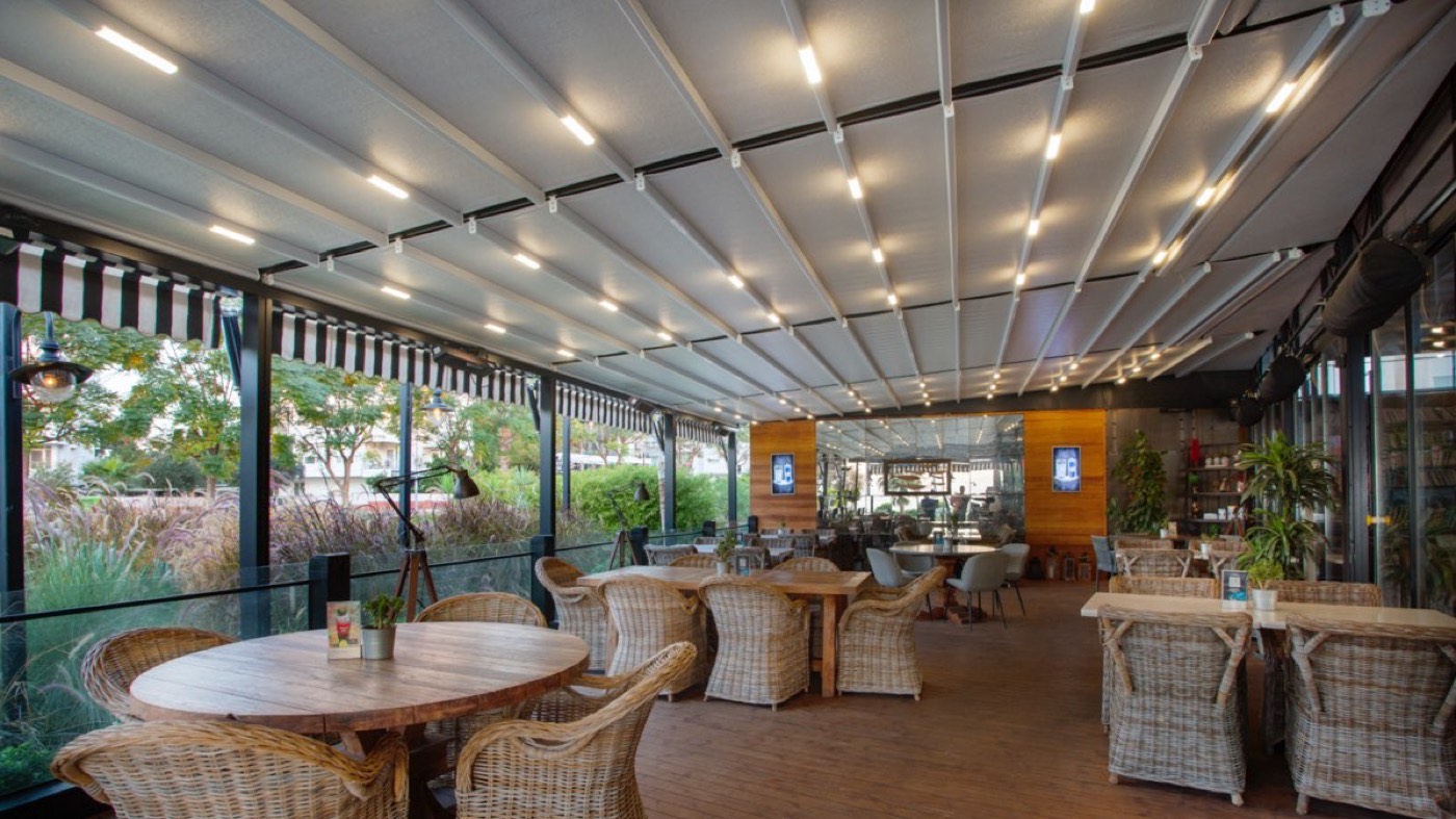 Faltdach mit LED-Beleuchtung über einer großen Restaurantterrasse